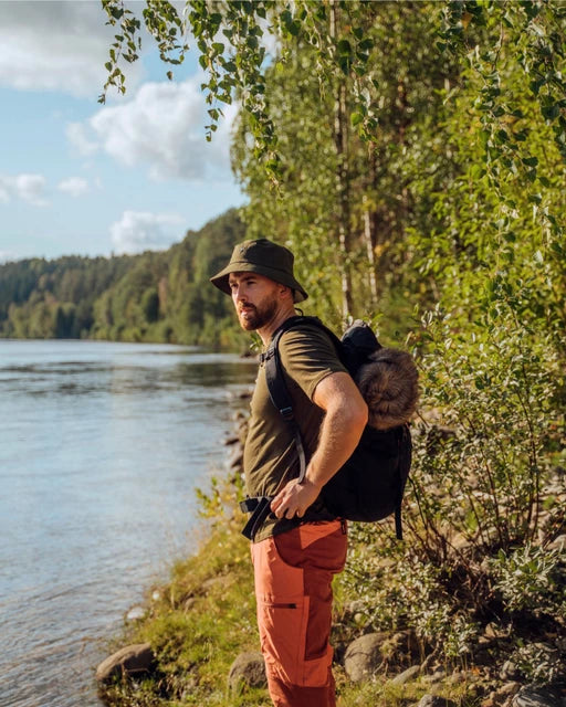 Mörkgrön InsectSafe hatt vid sjöstrand med ryggsäck