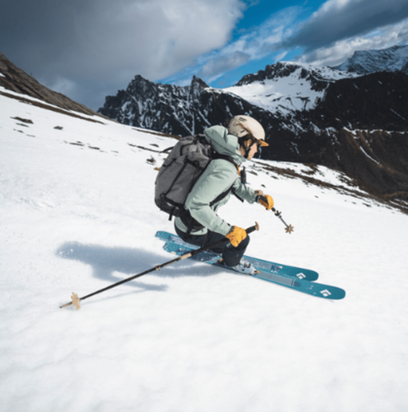 Skidåkare använder Black Diamond Helio Carbon 95 på snöig bergsluttning