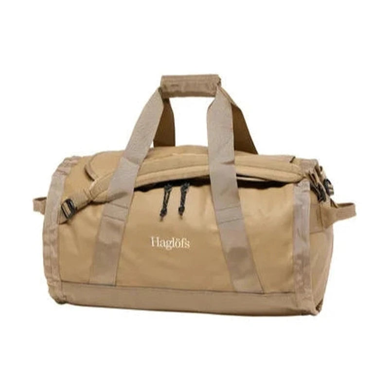 Vänster sida av beige Haglöfs Lava 50L duffelväska med detaljerad vy av handtag