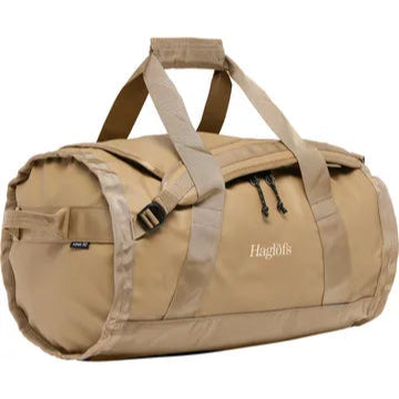 Beige Haglöfs Lava 50L duffelväska i trekvartsprofil med handtag och dragkedja