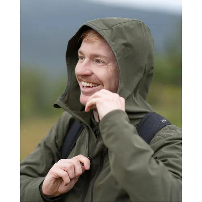 Mörkgrön skaljacka med huva i utemiljö