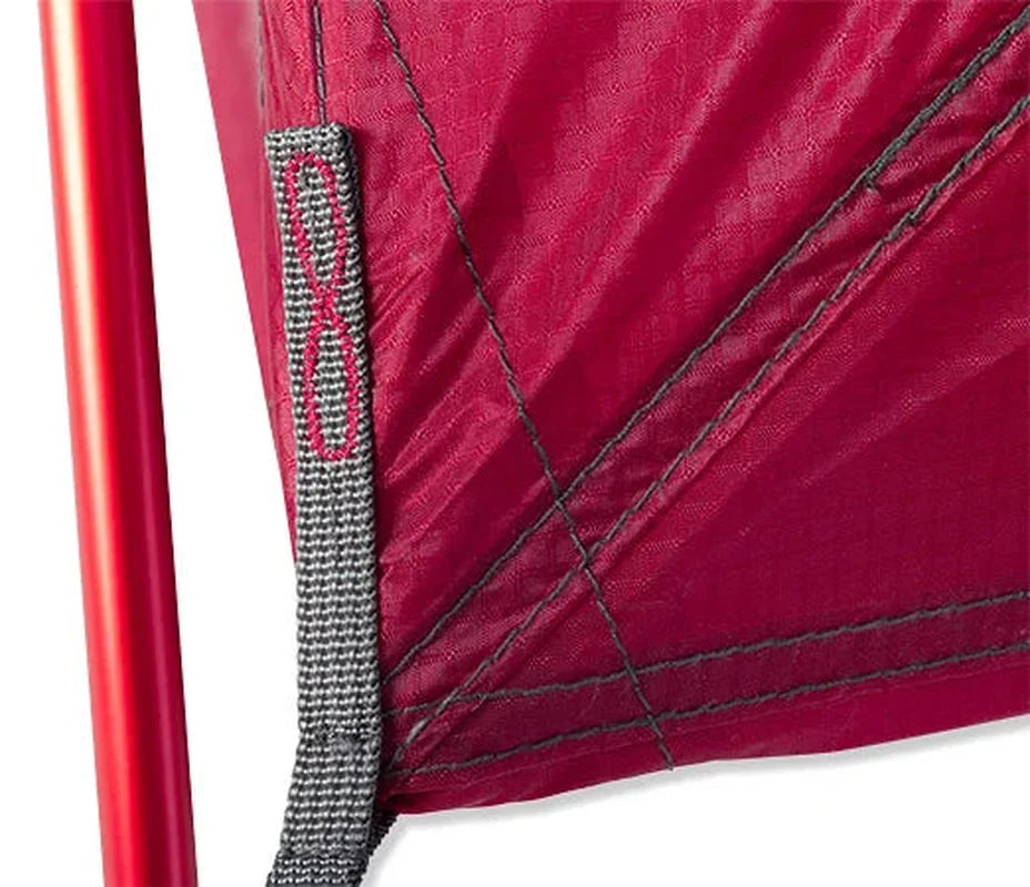 Närbild på tältets röda tygbas med vävd rem och sömnadsdetaljer