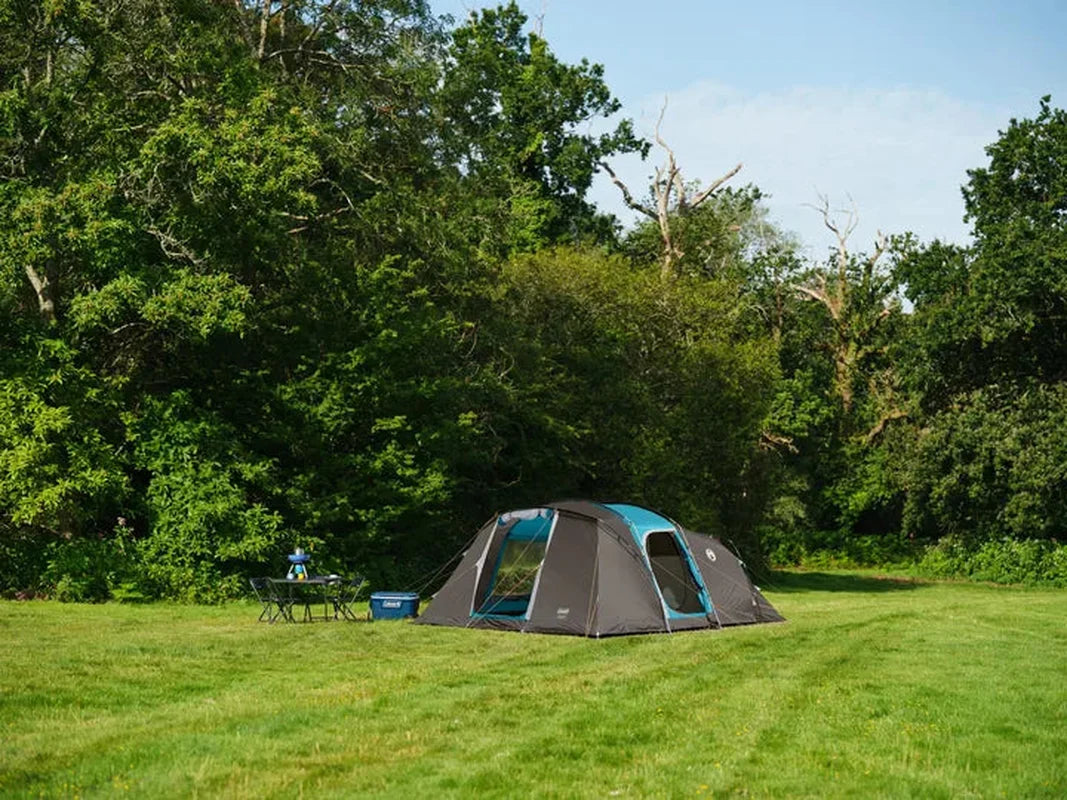 Vespucci 6 campingtält uppställt på gräs med bord och stolar