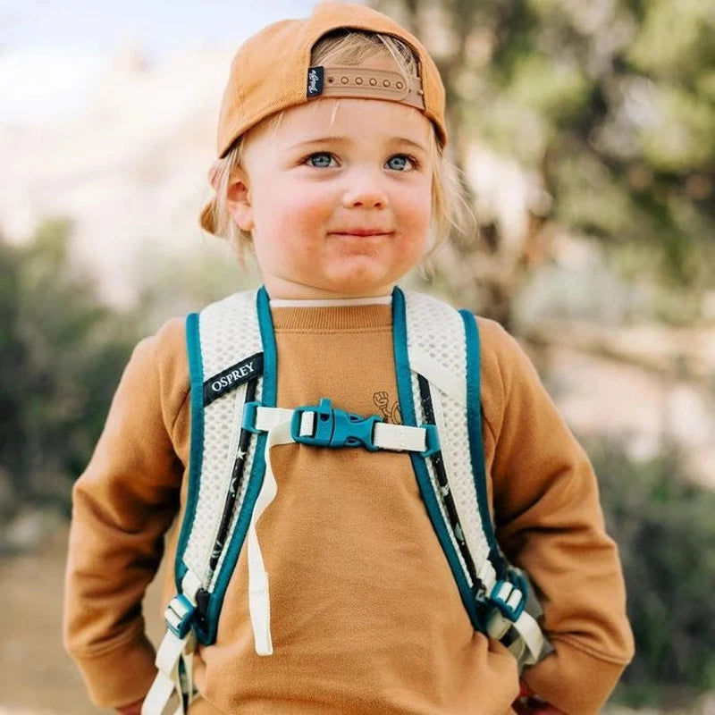 Barn bär Osprey Daylite JR ryggsäck med vita mesh-axelremmar utomhus