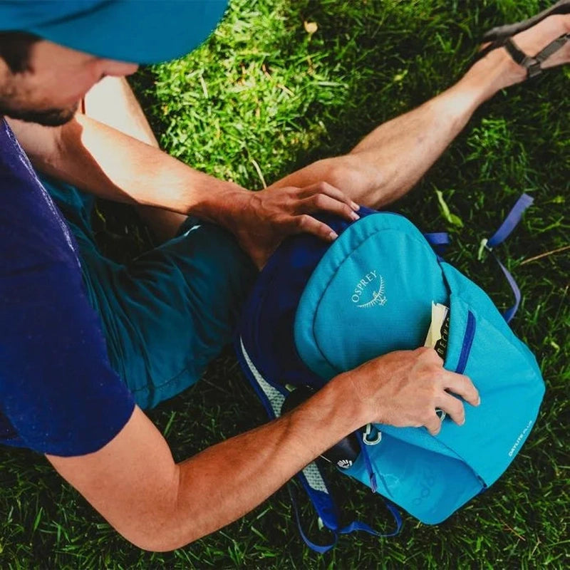 Ljusblå Osprey Daylite Plus ryggsäck öppen för packning utomhus