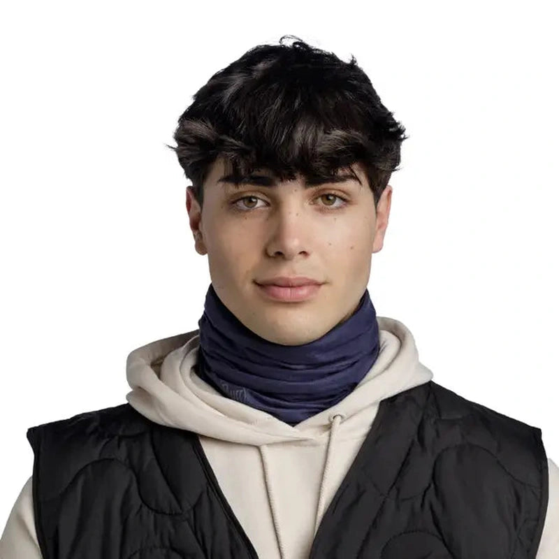 Man som bär mörkblå Buff Original Ecostretch under väst