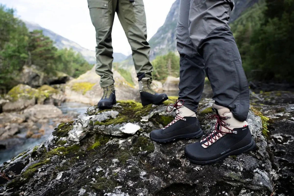 Två personer i Alfa Gneis GTX kängor på bergsten vid å