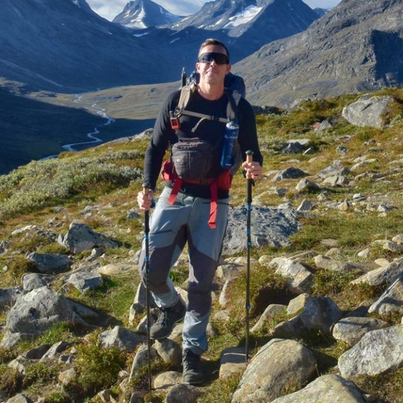 Man vandrar i mörkgröna kängor på bergsstig