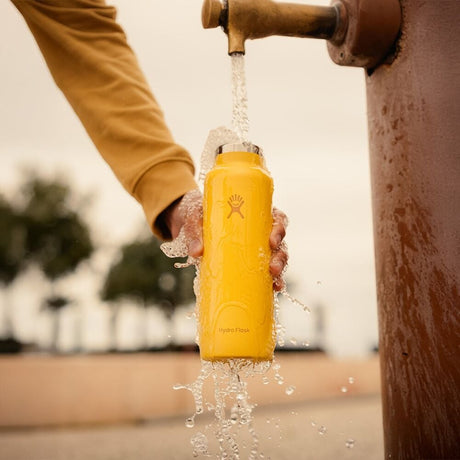 Gul Hydro Flask vattenflaska under rinnande vatten för att visa rengöring