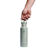 Ljusgrön Hydro Flask vattenflaska hållen i bärhandtaget för storleksreferens